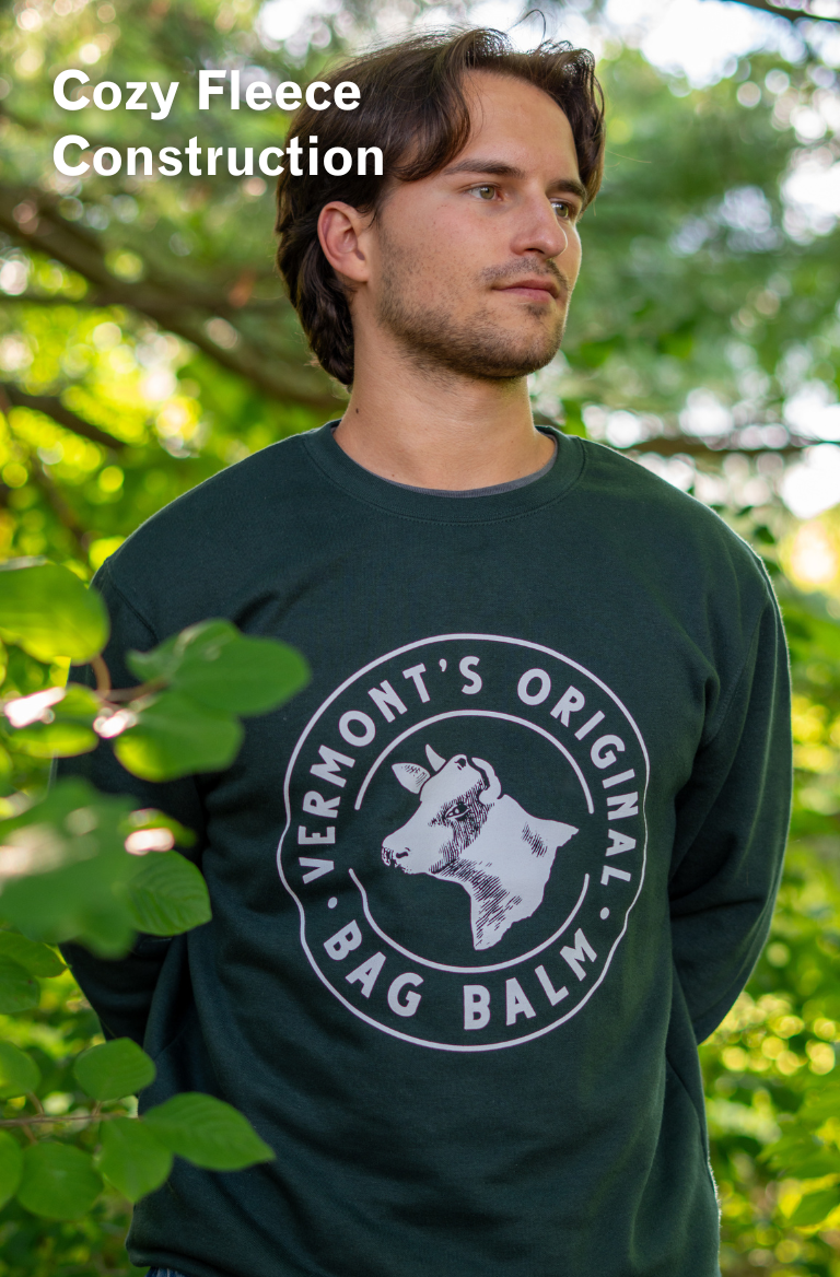 A man wearing a crewneck sweatshirt with a cow + crest design.