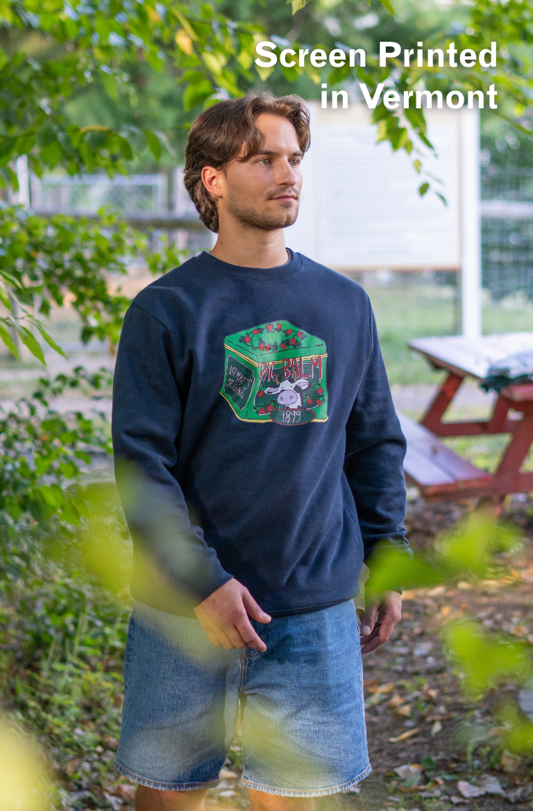 man wearing a crewneck sweatshirt with a cow + tin design