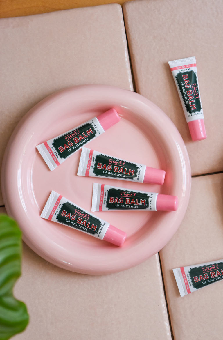 Tubes of pink lip balm on pink plate