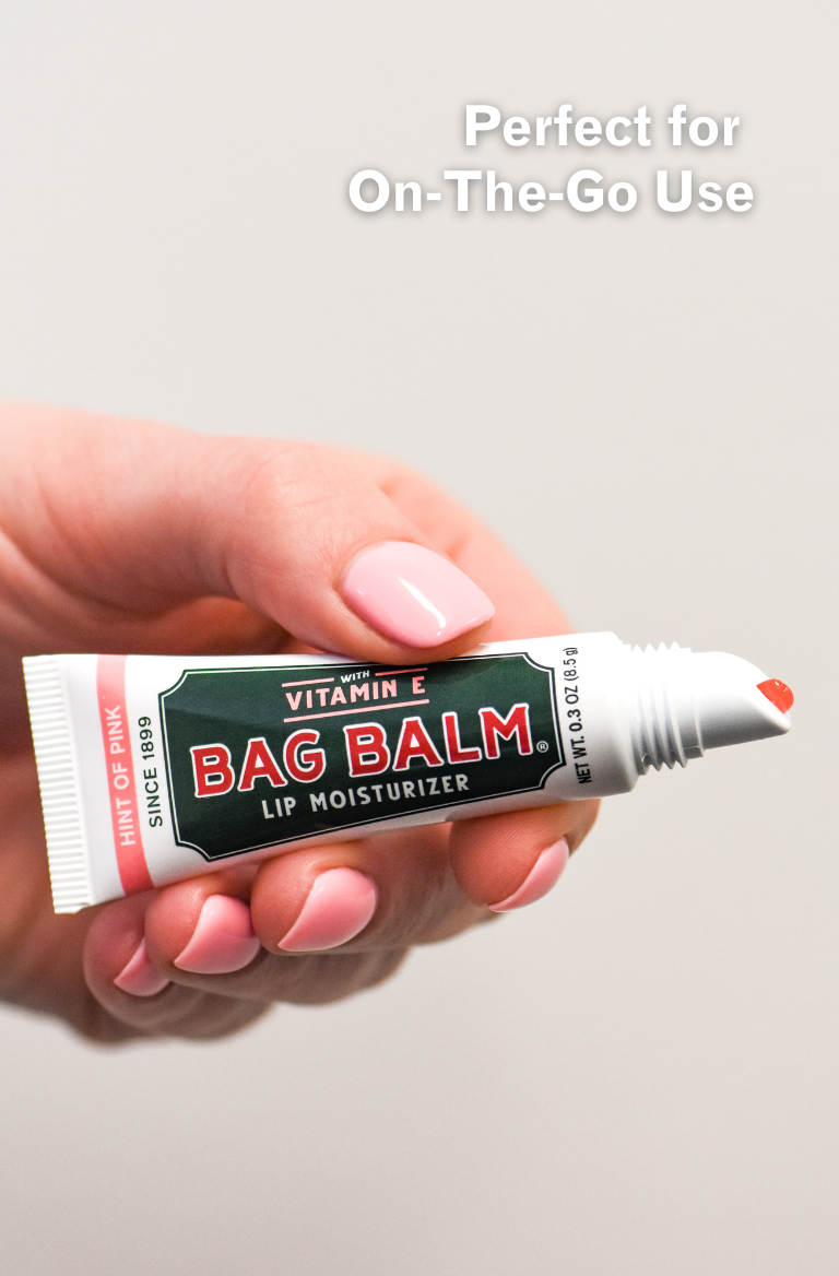 Hand holding tube of pink lip balm