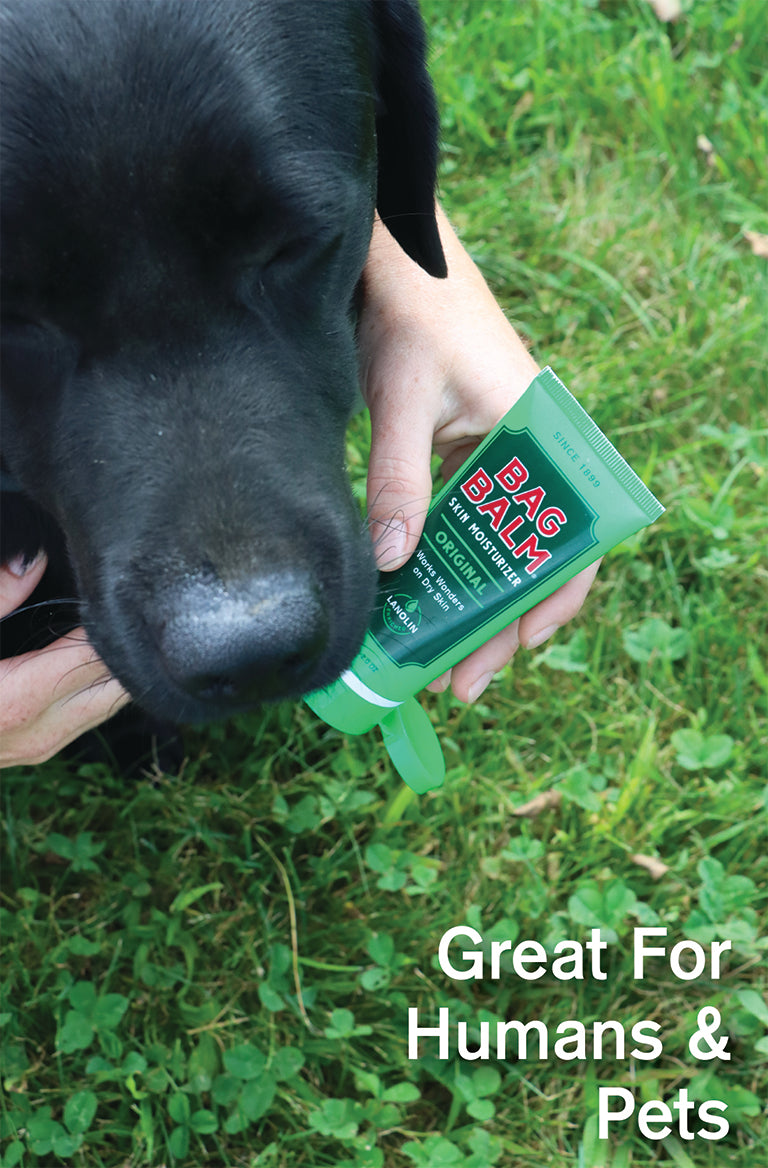 Bag Balm 2oz Tube next to a black dog