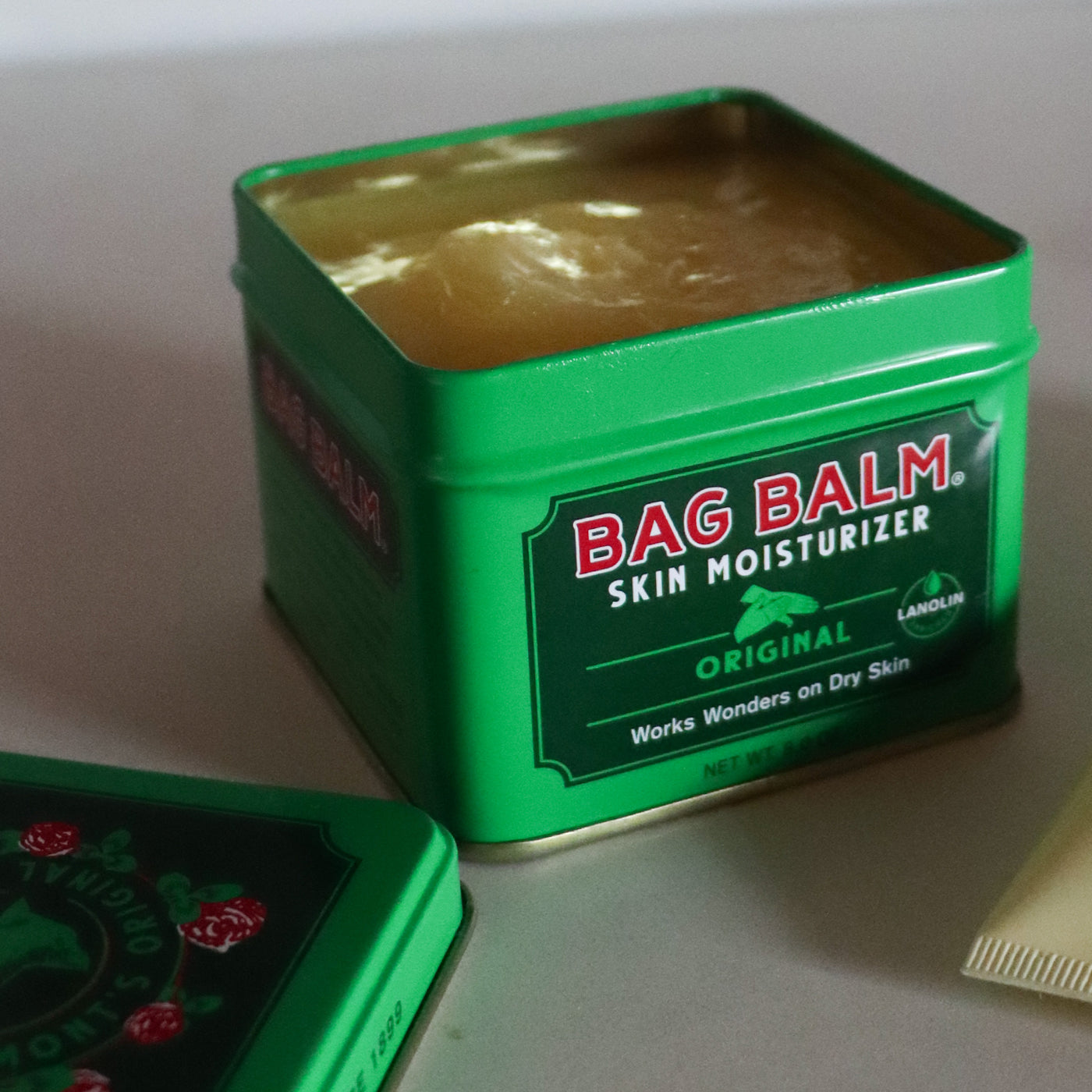 An open green tin of Bag Balm