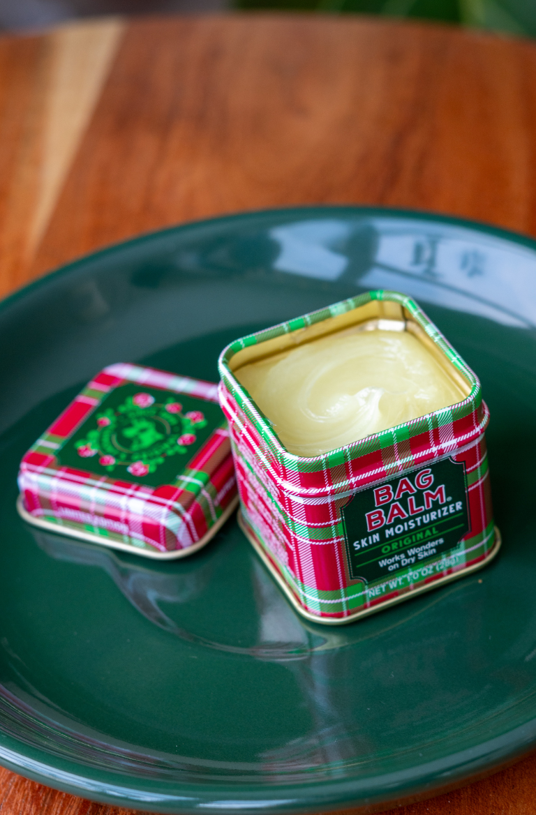 bag balm mini tin on a green plate
