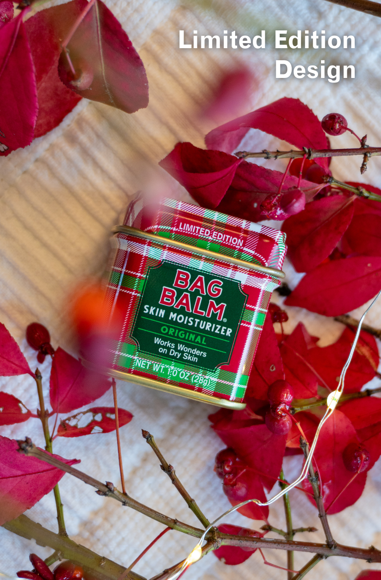 Bag Balm skin moisturizer with red leaves and berries on a textured surface