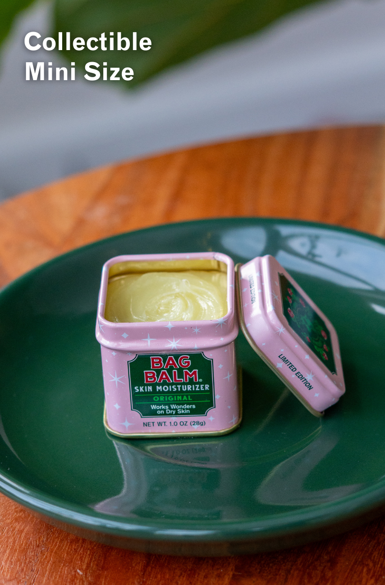 Pink tin of Bag Balm on a green plate with text indicating 'Collectible Mini Size'.