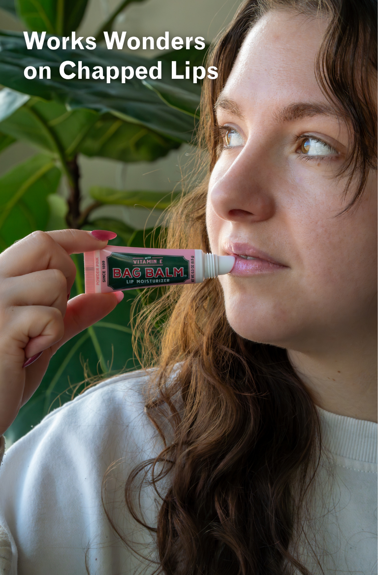 Woman applying a lip balm with text 'Works Wonders on Chapped Lips' and a plant in the background.