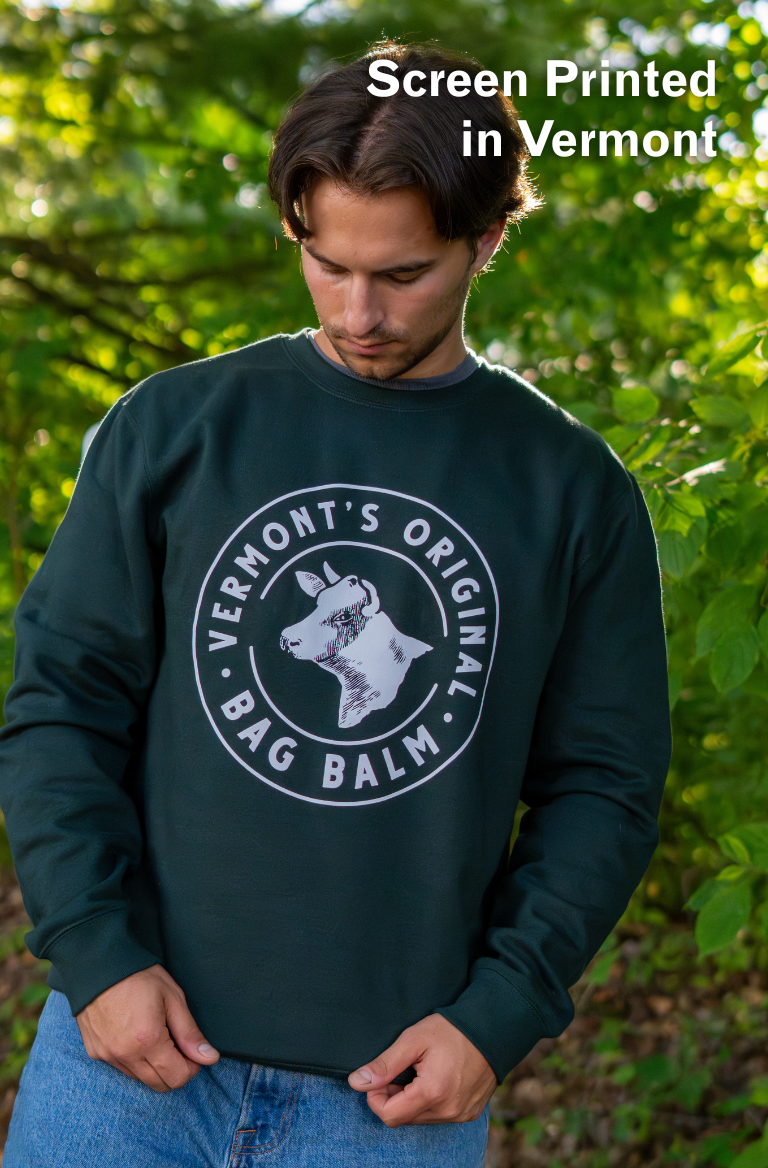 A man wearing a crewneck sweatshirt with a cow + crest design.
