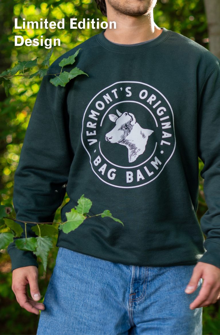 A man wearing a crewneck sweatshirt with a cow + crest design.