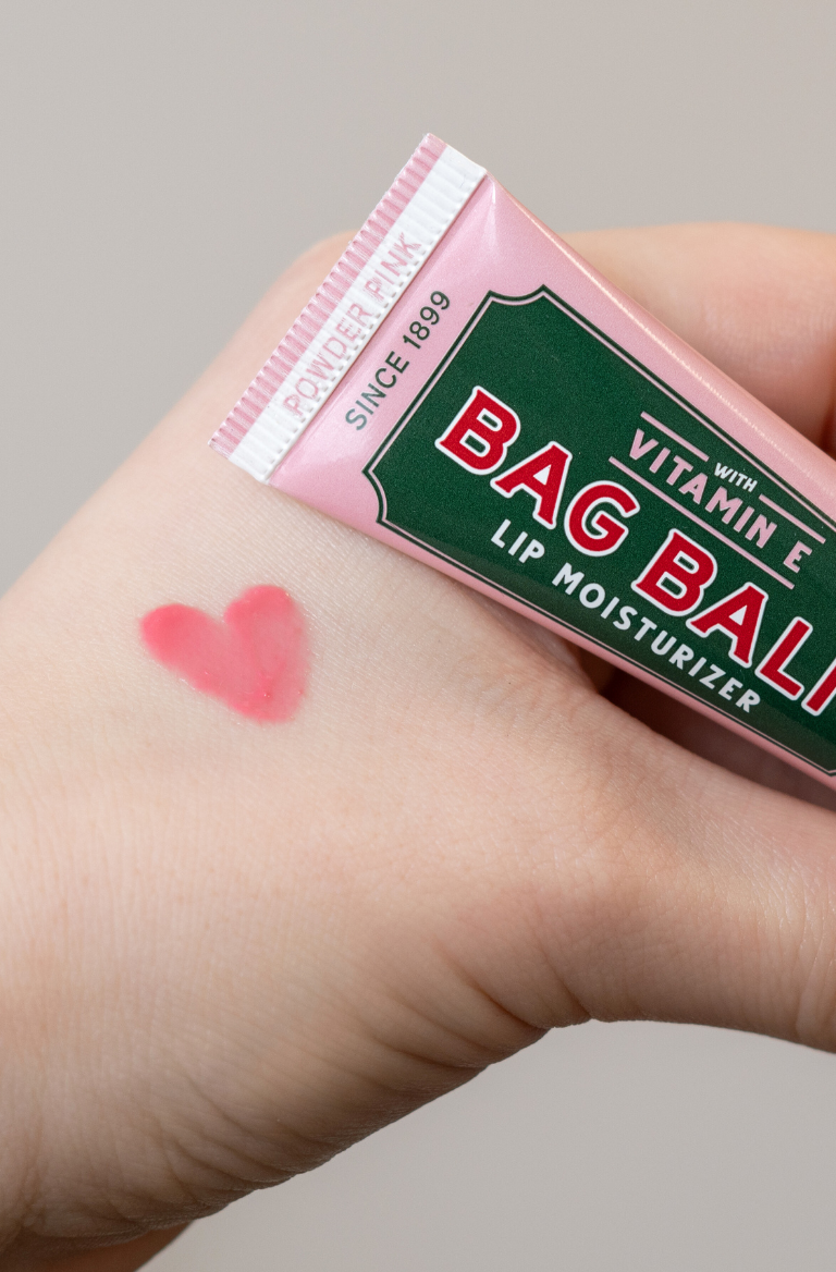 Hand with heart-shaped swatch of Bag Balm Powder Pink Lip Moisturizer