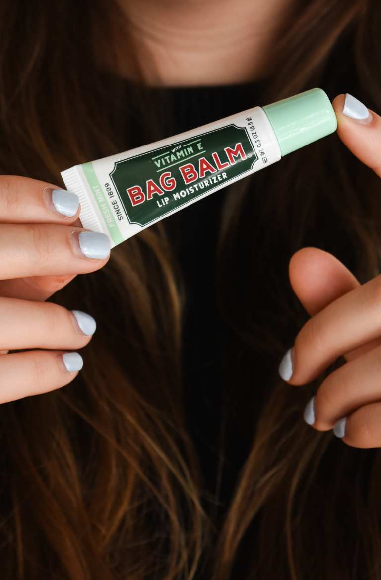 Woman holding tube of mint lip balm