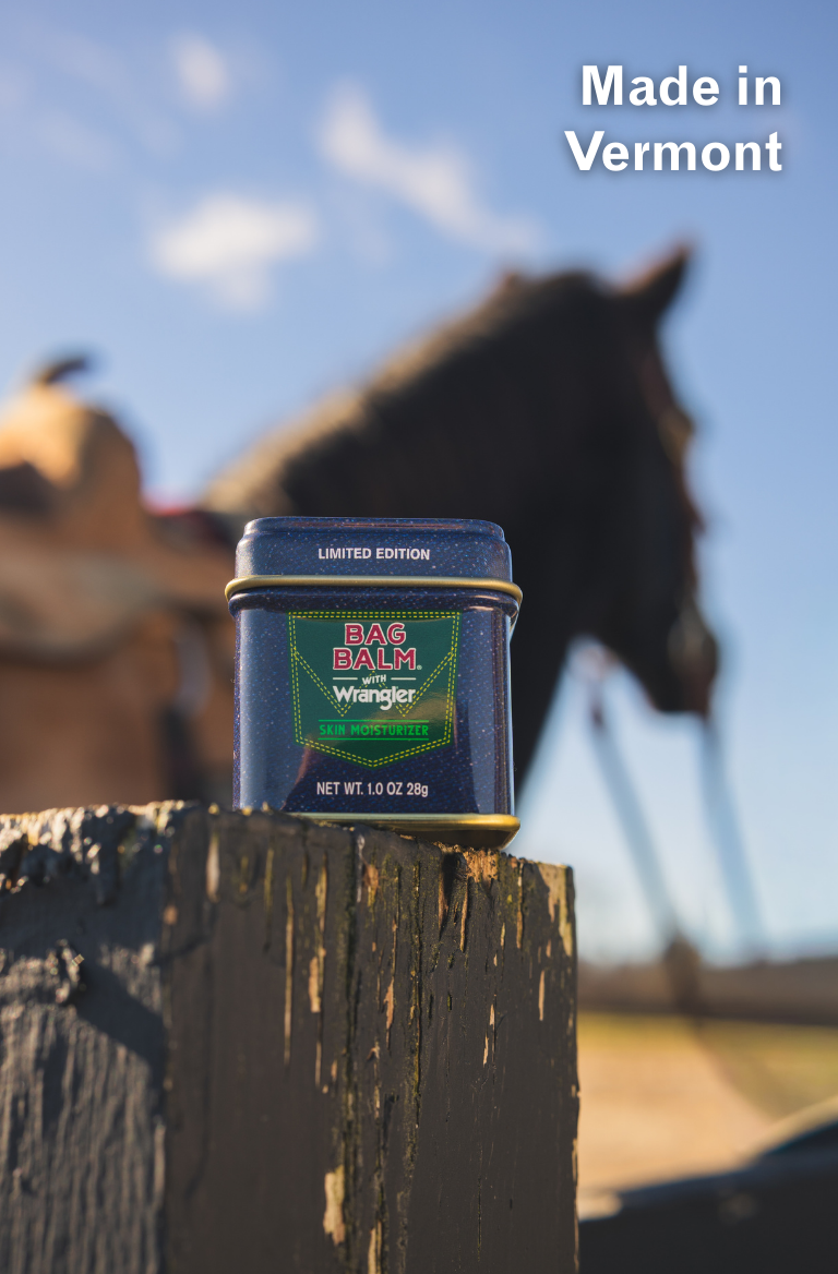Limited Edition Denim Design Bag Balm 1oz tin in collaboration with Wrangler on fence post in front of a horse.