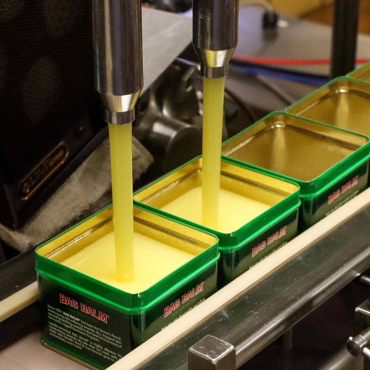Green tins of Bag Balm being filled in a factory