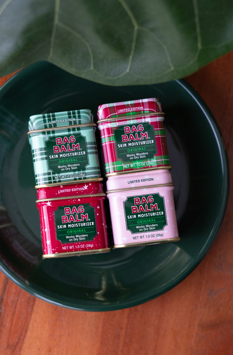 Four tins of limited edition Bag Balm mini tins on a green plate